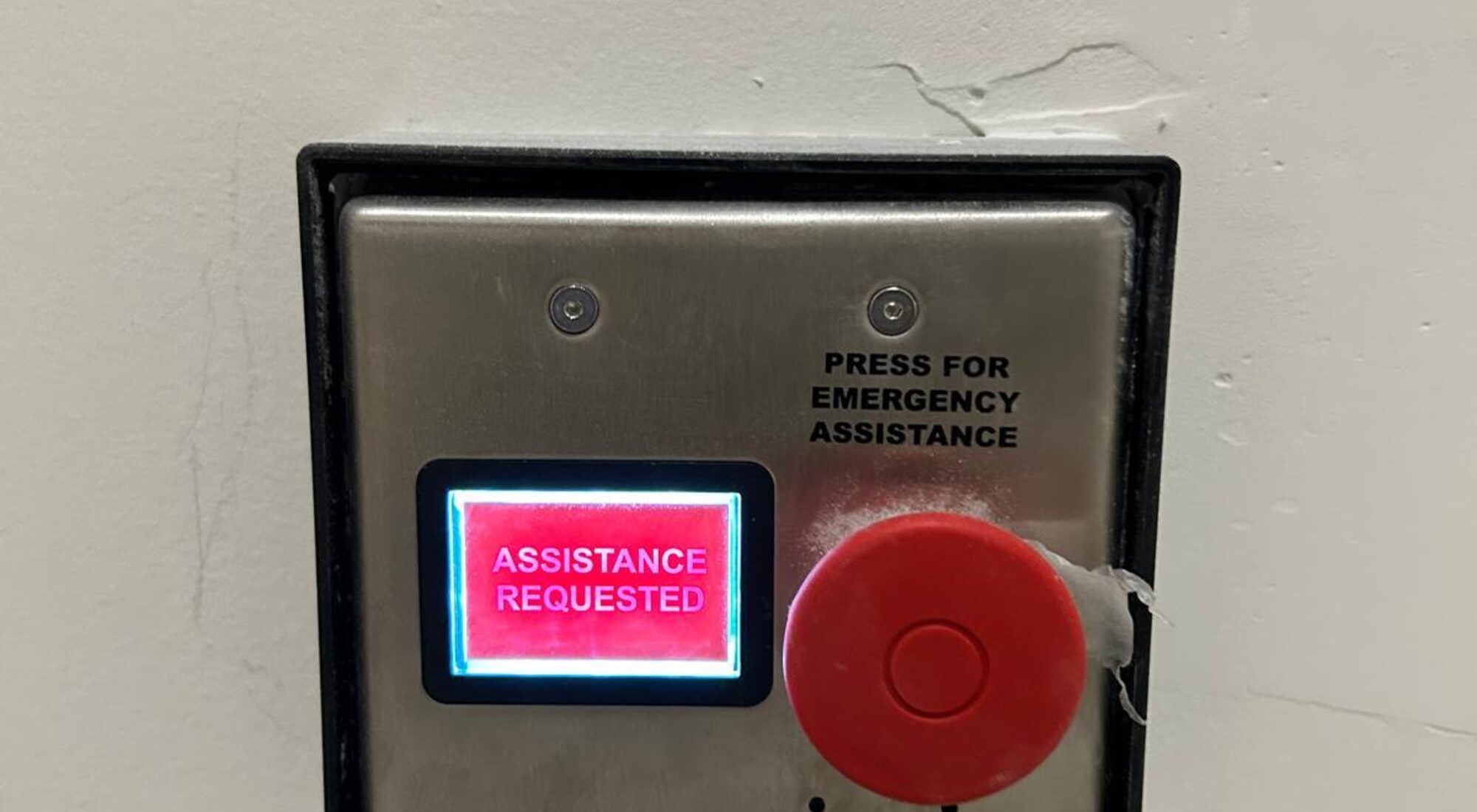 Wall mounted emergency assistance call point showing an assistance requested indicator