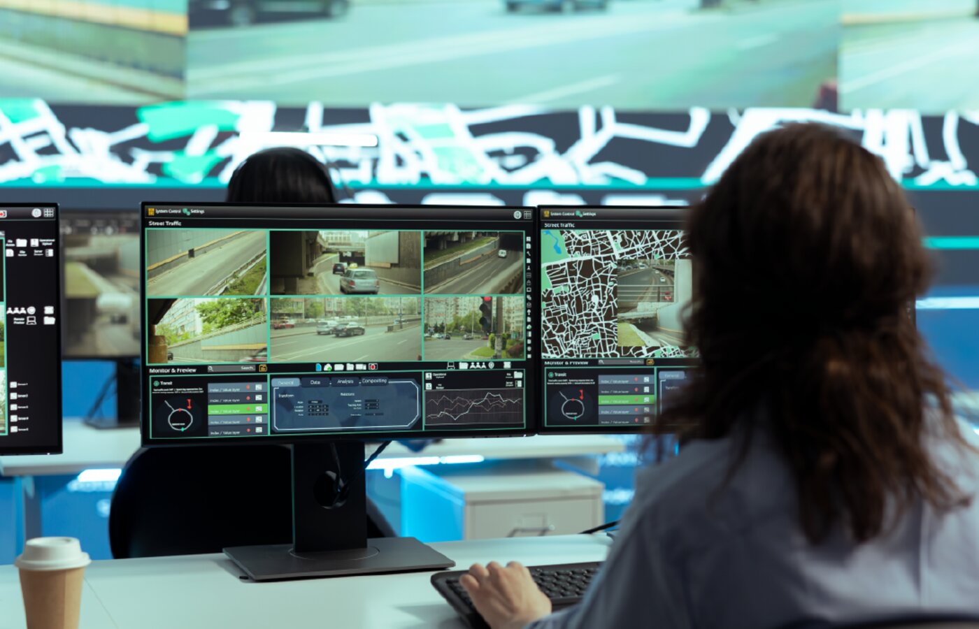 Operator reviewing recorded camera footage across several screens