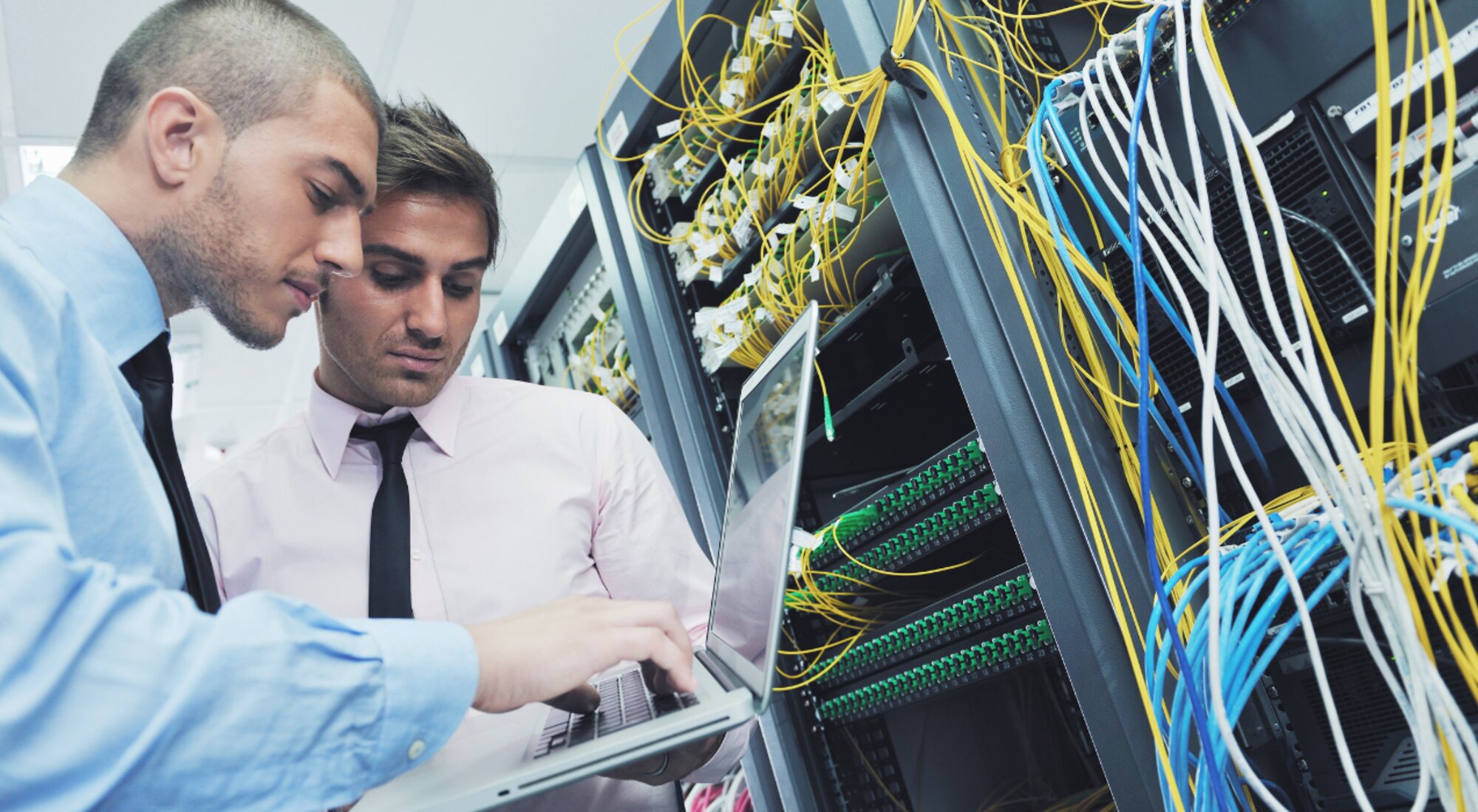 Technicians terminating cabling in a rack