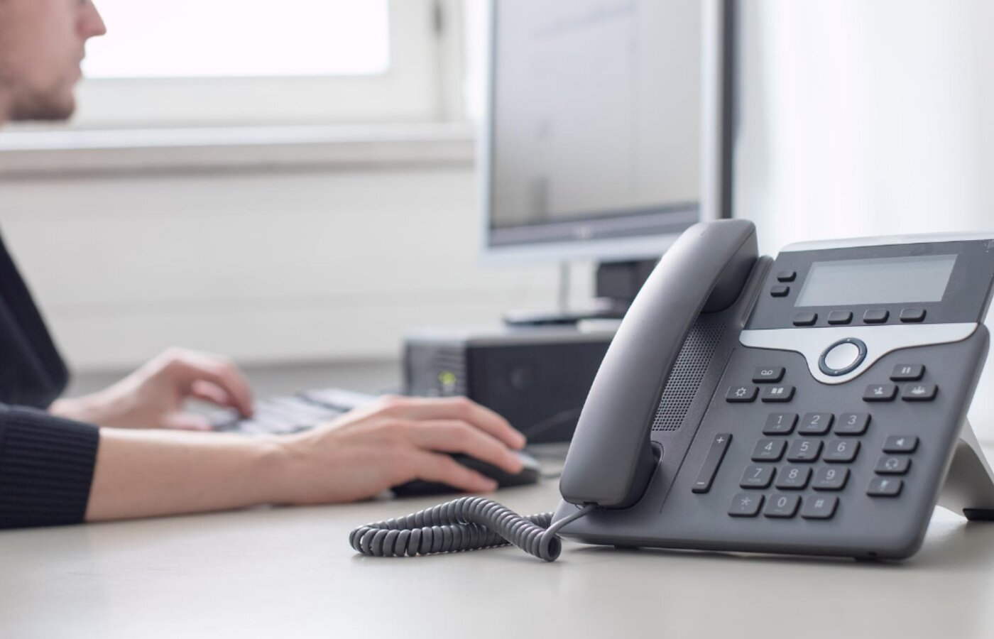 Desk phone in use at an office workstation