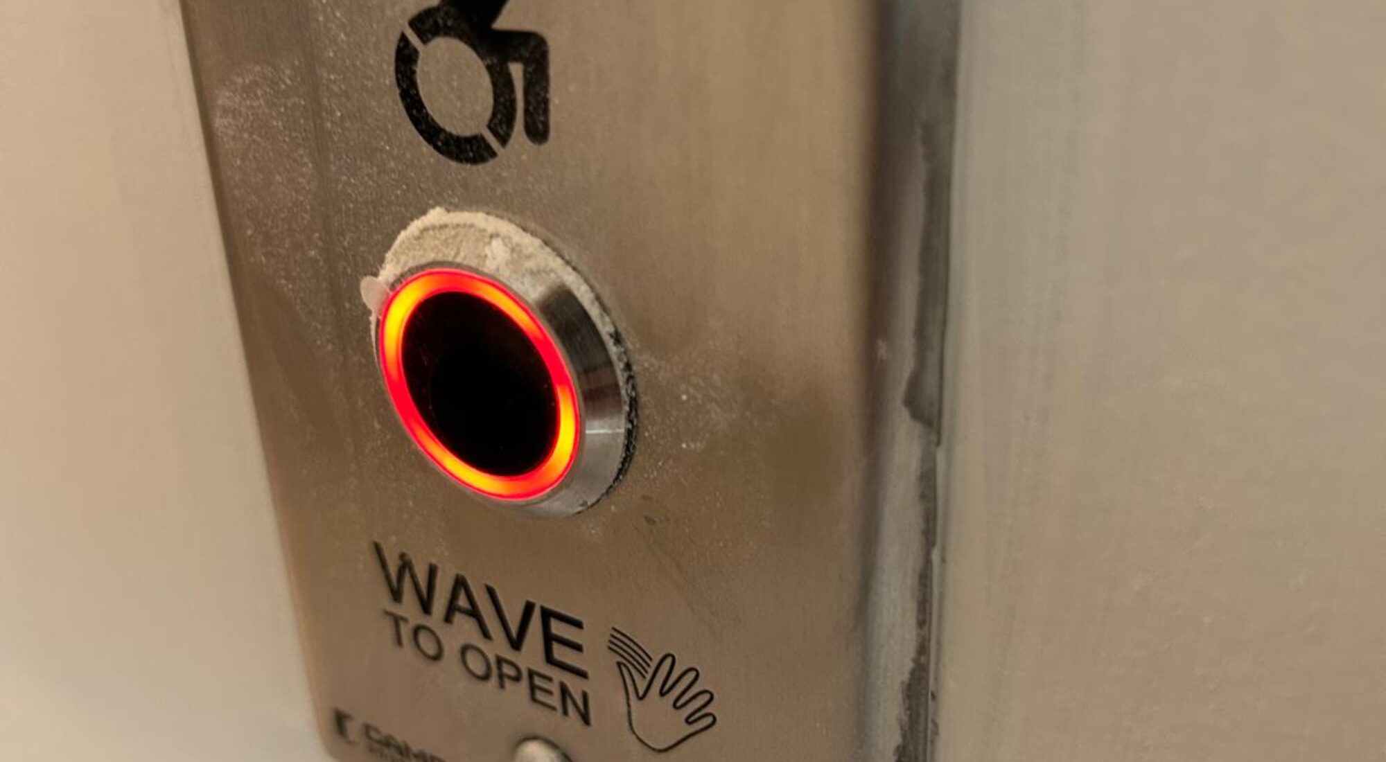 Stainless wave to open actuator beside a universal washroom door